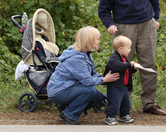 Mary Wilson crouches down with grandson Benjamin McWaters as Benjamin cheers on his father, Rob McWaters