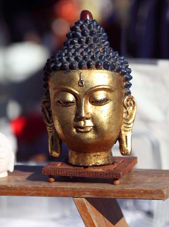 A foot-high Buddha statue is utterly peaceful in a sea of activity.