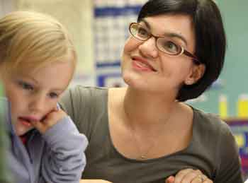 Second-grade teacher Dawn-Marie Ayles and visiting kindergartener Lauren Lindsey listen to a story written by one of Ayles’ second graders. (Photo by Lisa Aciukewicz) Second-grade teacher Dawn-Marie Ayles and visiting kindergartener Lauren Lindsey listen to a story written by one of Ayles’ second graders. (Photo by Lisa Aciukewicz)