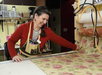 Liz Hawkes at work in her home making window treatments. (Photo by Lisa Aciukewicz)