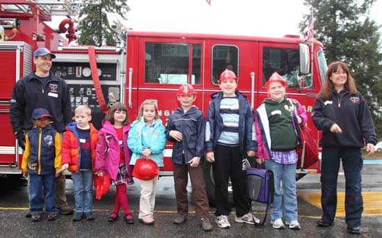The individual winners of the fire safety poster awards line up in front of the fire truck after riding in it to school on Nov. 8. Left to right are firefighter Bill Barton, Derek Springer, William Thomas, Erin Flynn, Anne Sagaloff, Clayton Hanlon, John Hart, Allison Milliken, and SAFE Coordinator Oona Adlrich.