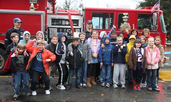 Mrs. Piche’s fourth grade poses with the trophy for winning the class prize for fire safety. 