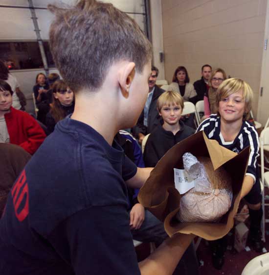 Thomas Berthoud delivers a frozen turkey to Caeden Bishop.