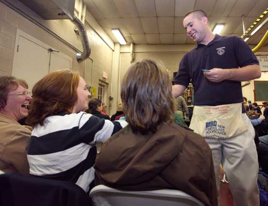 Patricia (left) and Kelley O’Malley purchase tickets from firefighter Tyler Swearingen. 