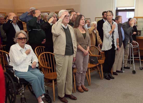 Veterans salute and civilians place their hands over their hearts during the Pledge of Allegiance.