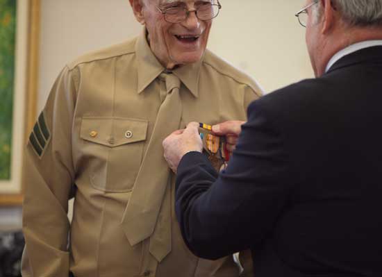 Bill Doe smiles as Bob Eubank pins a medal on his uniform during a Veterans Day ceremony on Nov. 11.