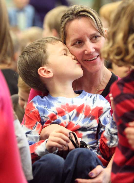 Aidan Long gives his mom, Andrea, a spontaneous kiss at a Thanksgiving sing-a-long at the elementary school on Nov. 22.