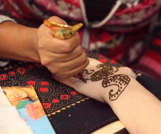 Suraiya Suliman creates an intricate henna design on Rachel Strathdee’s hand.