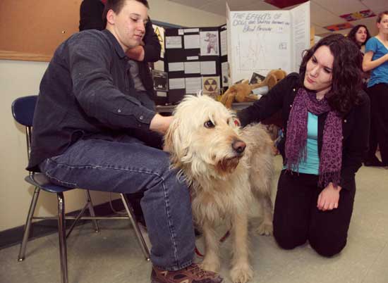 Cameron Hamilton (left) and Annie Cooper with "Darwin" at a project that measures the effects on dogs and stuffed animals on blood pressure.