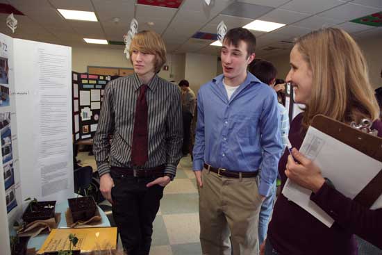 Matt Chambers (left) and Declan Dean explain their experiment on magnetic plants to Virginia Justicz.