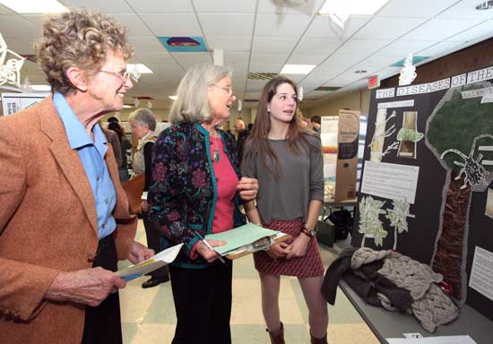 Judges Chris Ready and Louisa Van Baalen speak with senior Emma Rothkopf about her project on diseases of the trees of Harvard.