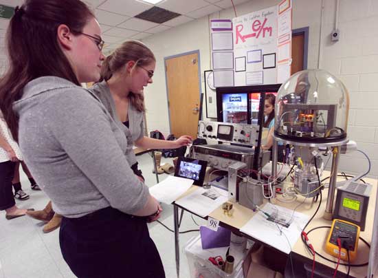 Juniors Rachel Strathdee and Adeline Gall demonstrate equipment they built to experimentally prove the cyclotron equation.