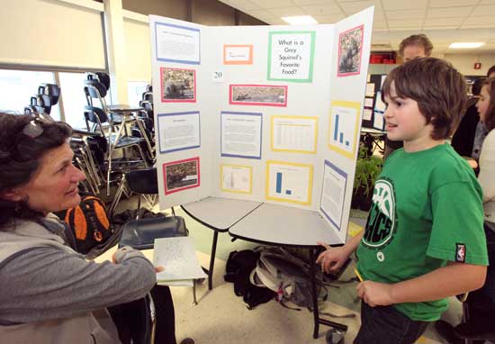 Wendy Sisson of the Harvard Conservation Commission asks Teague Neschke about his experiment on food preferences of grey squirrels.