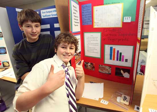 Nick Wyman looks over the shoulder of Matty Banker who’s thumbs up on his project on dusting for finger prints at the Bromfield Science Fair in February.