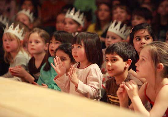 Children at the edge of the stage watch the performances intently