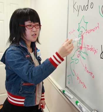 Manami Abe draws a map to illustrate what part of Japan was affected by the recent tsunami. 
