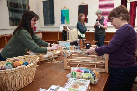 Laura Busky (left) and Joan Paul  try out the looms from the Fiber Loft.