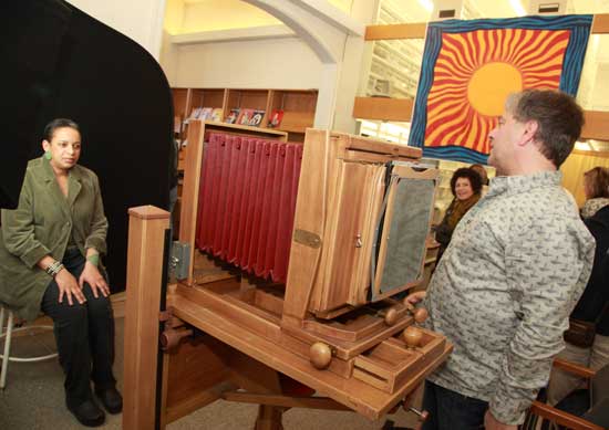 Sharon Chandler (left) poses as Bob Hubert adjusts his 8x10 large-format camera for a portrait.
