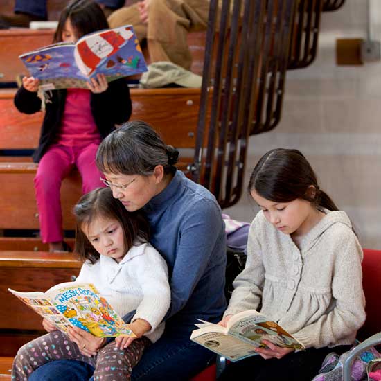 Yookyung Selig (center) and her daughters Anna, 2, Sara, 6, and Kate, 9 read in the corner of the gym. 