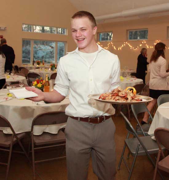 Ross Brown-Cullinane offers grilled shrimp to Gala guests at the Unitarian Fellowship Building.