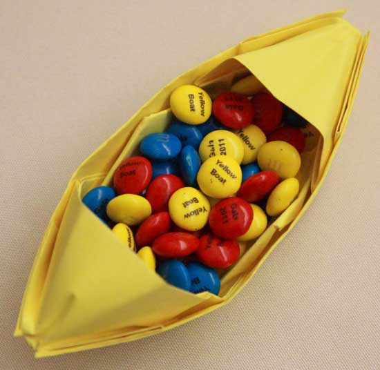 Origami yellow boats filled with specially printed “Yellow Boat” M&Ms adorn the tables