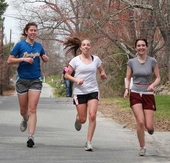 From left, Julia Alexander, Sydney Durand, and Harriet Hill hit their stride as they jog down Madigan Lane during the Good Friday Walk. 