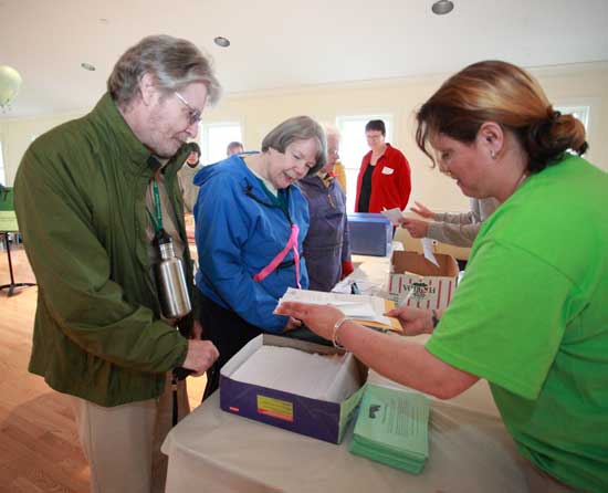 From left: Michael and Nancy Henry turn in $1,750 of pledges to volunteer Christine House after completing the 5-mile Good Friday Walk, a fundraiser for Loaves & Fishes, April 22.