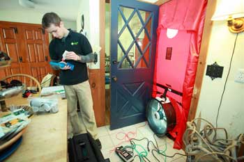 Farrell sets up to conduct a blower door test. (Photo by Lisa Aciukewicz)