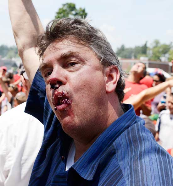Will Woodruff, with a full mouth of blueberry pie, raises an arm to signify he has finished eating. (Photo by John Sharko)