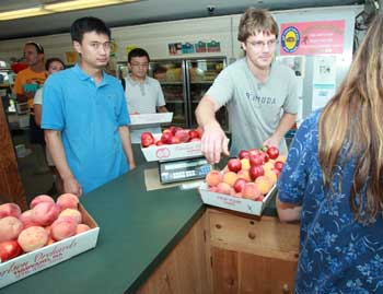 From left: Chen Xin and David Zhang watch as Sam Poutasse of Depot Road purchases peaches during Carlson Orchards’ Peach Festival Aug. 20. (Photo by Lisa Aciukewicz) From left: Chen Xin and David Zhang watch as Sam Poutasse of Depot Road purchases peaches during Carlson Orchards’ Peach Festival Aug. 20. (Photo by Lisa Aciukewicz)