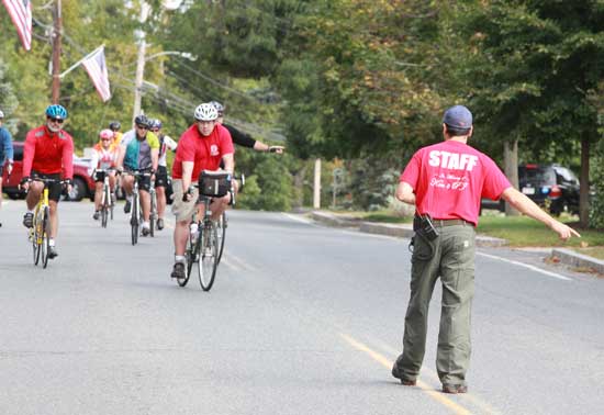 Riders in the Ken Harrod Memorial Bicycle Ride respond to the direction of Bill Barton as they cruise down Ayer Road.