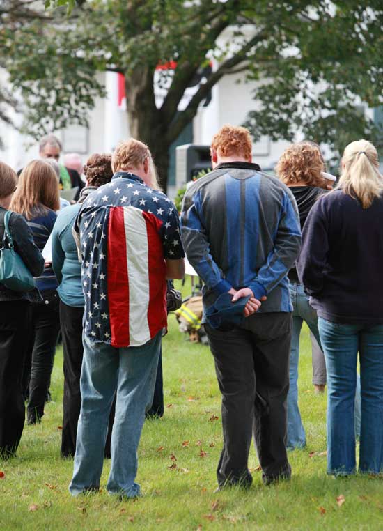 Participants on the common listen with heads bowed.
