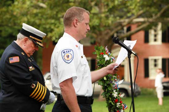 Selectman and former Fire Chief Peter Warren (left) listens with bowed head as Fire Chief Rick Sicard reads the Fireman’s Prayer.