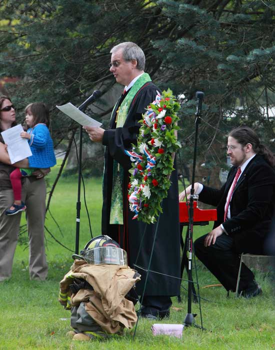 Those gathered at the memorial on the common sing "Let There Be Peace on Earth."