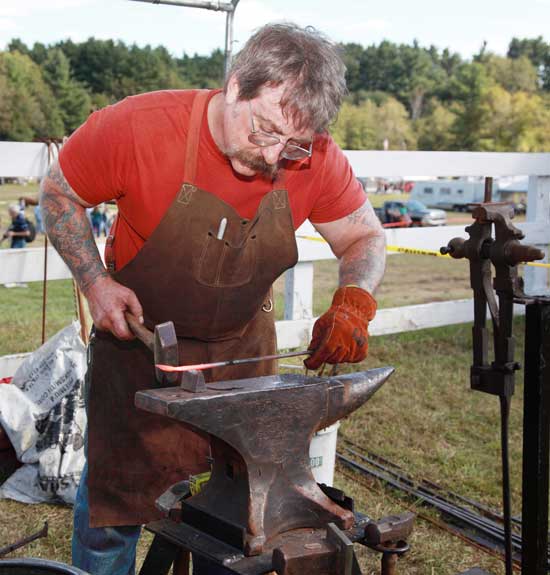 A blacksmith demonstrates his craft.