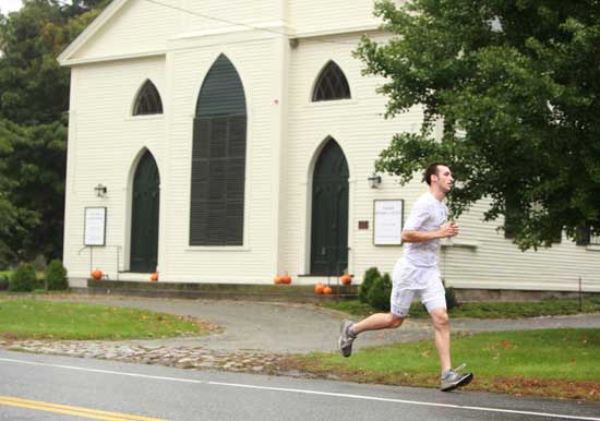 General Store employee Merton Thompson runs past the Harvard Historical Society. Thompson won General Store smackdown award as the first employee to finish. 
