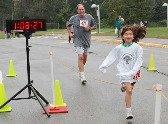 Bob Douglas and his daughter Emily cross the finish line for the 5-mile race. Emily was the youngest registered runner in the race. 