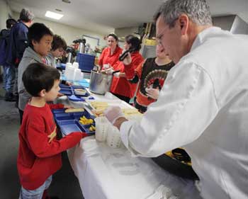 Chef Paul Correnty serves peaches at a shelter lunch on Oct. 31. (Photo by Lisa Aciukewicz)