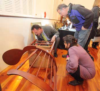 Stuart Miller examines a chair brought in by Bruce and Joyce Gallagher. (Photo by Lisa Aciukewicz) Stuart Miller examines a chair brought in by Bruce and Joyce Gallagher. (Photo by Lisa Aciukewicz)