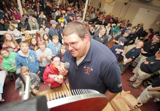 Firefighter and emcee Andrew Perry checks the wheel for the winning number.