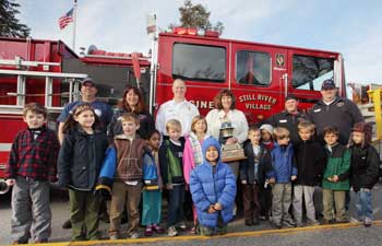 Lisa Hopkins’ first-grade class poses with the firefighters. (Photo by Lisa Aciukewicz) Lisa Hopkins’ first-grade class poses with the firefighters. (Photo by Lisa Aciukewicz)