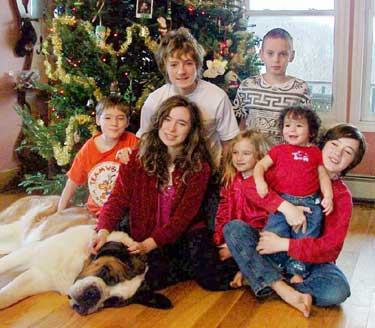 The Morin children in the family’s 2010 holiday photo. In front, from left: Sky (dog), Rebecca Morin, Monique Morin, Jamie, foster son, Michael Morin. Back row, from left: Jason Morin, Kenny Morin, and George, foster son. (Courtesy photo) The Morin children in the family’s 2010 holiday photo. In front, from left: Sky (dog), Rebecca Morin, Monique Morin, Jamie, foster son, Michael Morin. Back row, from left: Jason Morin, Kenny Morin, and George, foster son. (Courtesy photo)