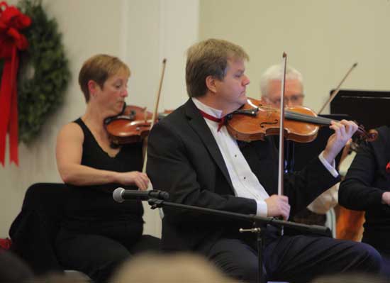Concertmaster Tim Arnold plays violin.