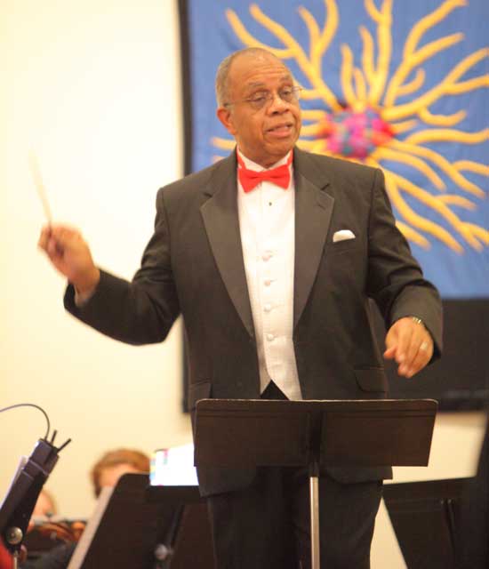 Ted Johnson conducts the orchestra and singers.