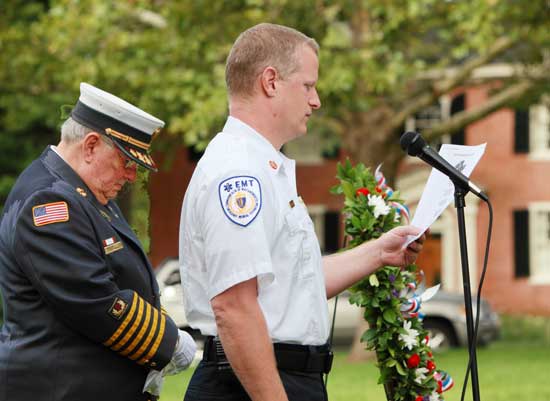 Peter Warren (left) listens with bowed head as Fire Chief Rick Sicard reads the Fireman’s Prayer at the Sept. 11 memorial service.