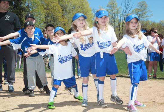 Softball players reach out to a passing runner in opening day activities, May 1.