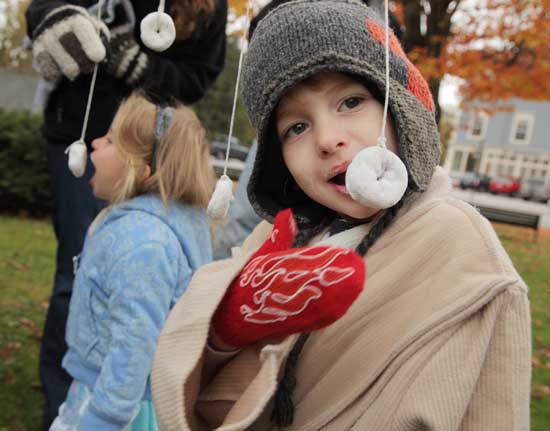 Maddie O’Brien and Barry O’Brien go after the powdered doughnuts on a string at the Harvard Family Association's Halloween Party on the Common.