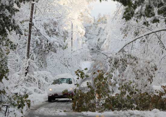 A car travels down a nearly impassable Still River Road after a freak Oct. 30 snowstorm that left Harvard without power for days.