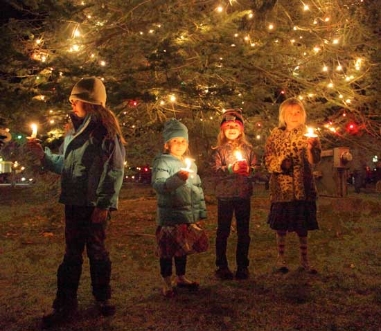 Young residents hold candles at the tree-lighting event on the Common in December. 