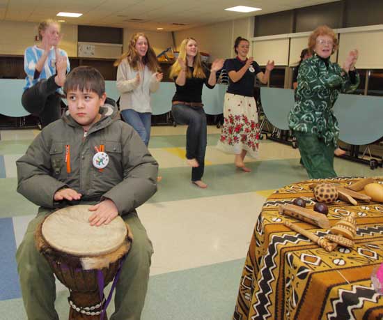 Henry Anderson (center) plays a drum as Judy Lorimer (far right) teaches an African dance to a group of students